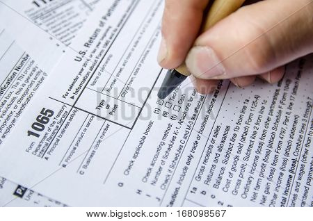 Person completing 1065 tax form close up