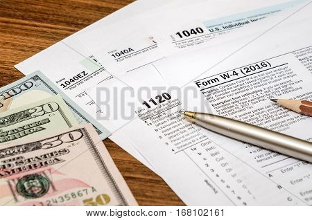 tax form w4 1040 1120 with pen and us dollar