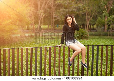 Smiling Girl Portraiture sit hand rail at the park