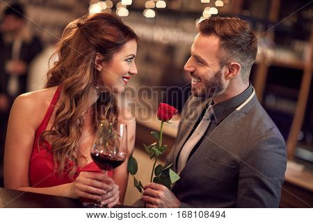Handsome man giving rose to attractive lady