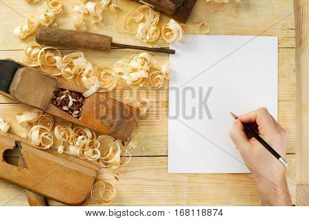 White sheet on wooden table for carpenter tools with sawdust. Copy space. Top view.