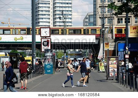 BERLIN, GERMANY - MAY 10: The busy and famous Alexander Square with pedestrians and passersby in fine weather near a subway bridge on May 10, 2016 in Berlin.