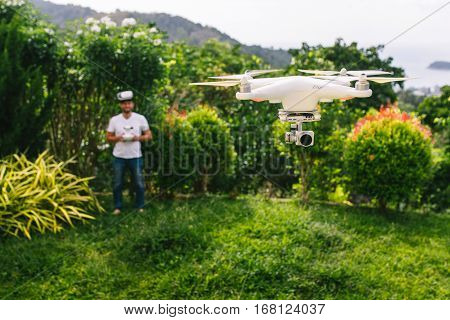 Man controls a quadrocopter. Selective focus on drone men is blurred