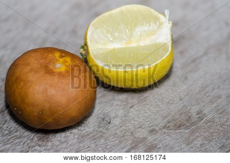 Lemon ripe withered unappetizing. Brown was placed on the wooden floor.
