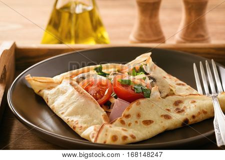 Pancakes sutffed with ham, cheese, tomatoes and mushrooms.