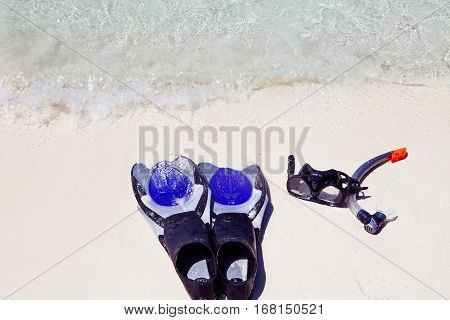 set of diving equipment on the ground next to a tropical sea coast