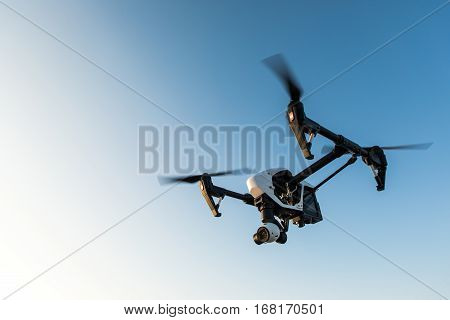 quadrocopter drone with remote control. Dark silhouette against colorfull sunset. Soft focus. Toned image