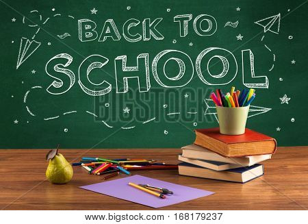Back to school concepty with writing on blackboard and desk, apple, books, items