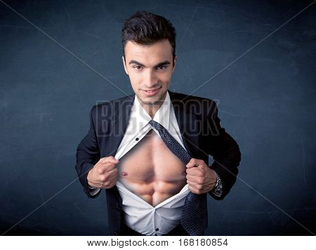 Businessman tearing off his shirt and showing mucular body concept on background