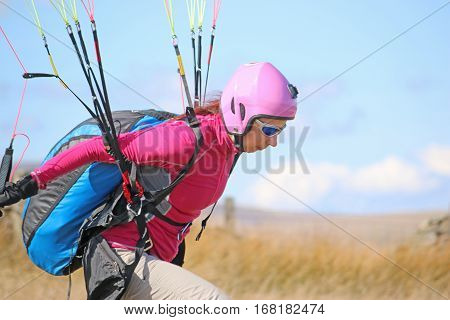 Paraglider launching herself from a hill top