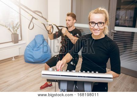 Happy Woman At The Gym And Man Training With Ems