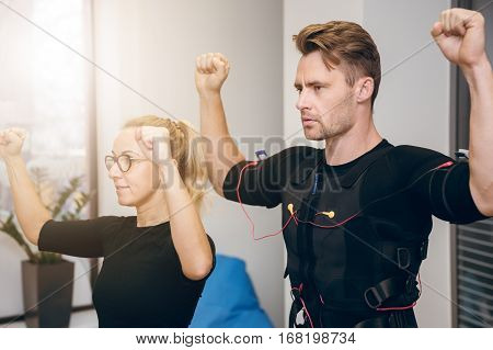 Serious Sportsman Working Out With Personal Coach At Gym