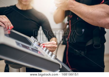 Trainer Hands Turning On Ems Device
