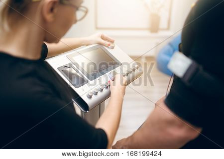 Woman Setting Up Ems Device For Sportsman