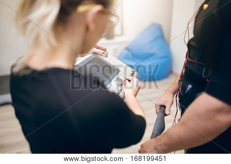 Trainer Setting Up Ems Device For Sportsman