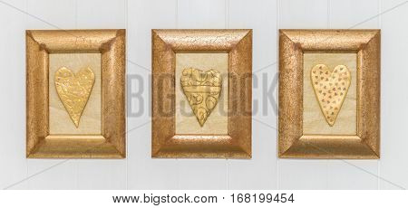 Three Framed Gold Hearts, White Background. Close Up.