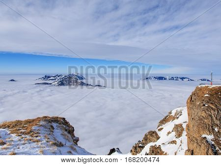 Summits of the Swiss Alps rising from sea of fog - wintertime view from Fronalpstock mountain in the Swiss Canton of Schwyz.