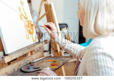 Do your best. Creative woman painting and using palette while spending time in painting studio