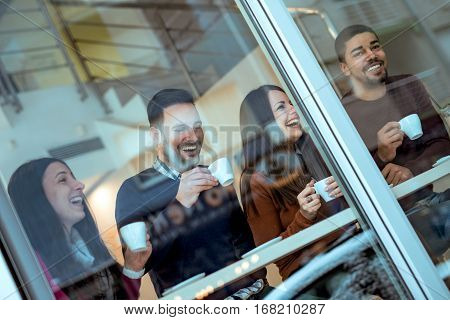 Friends having a great time in cafe.Friends smiling and sitting in a coffee shop drinking coffee and enjoying together.