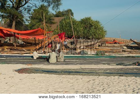 ZANZIBAR, TANZANIYA- JULY 13: fishermen,nets and wooden boats on the beach of fishing willage on July 13, 2016 in Zanzibar