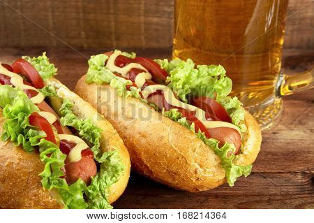 Hot Dogs With Glass Of Beer On Wooden Board
