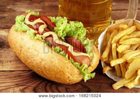 Hot Dog With Glass Of Beer With French Fries On Wooden Board