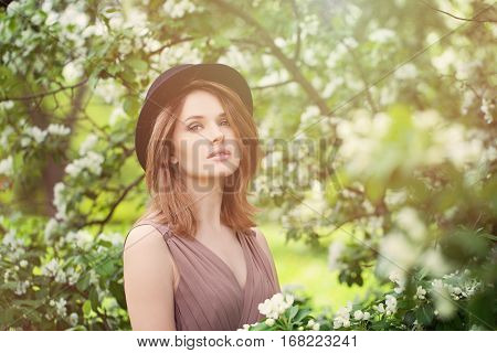 Young Beauty in Spring Sunlight. Healthy Woman on Bloosom Background Outdoors