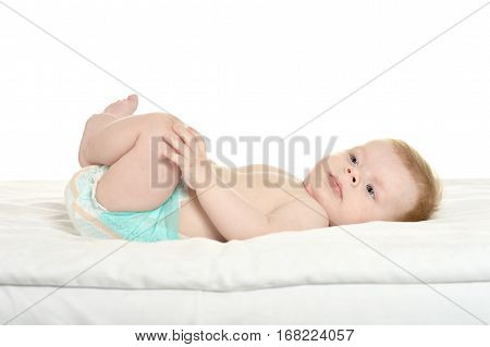 dorable baby boy in pampers on blanket on a white background