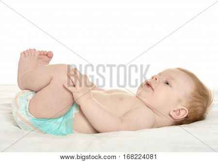 dorable baby boy in pampers on blanket on a white background