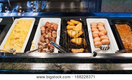 self-service buffet with meals for breakfast - bacon scrambled eggs fried sausages potato naggets boiled eggs etc