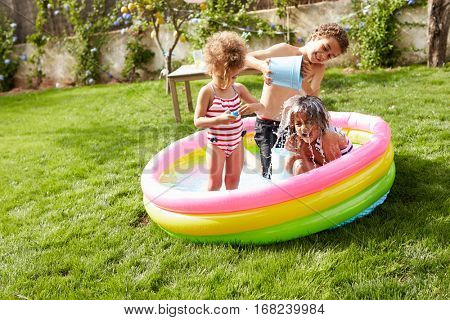 Children Having Fun In Garden Paddling Pool