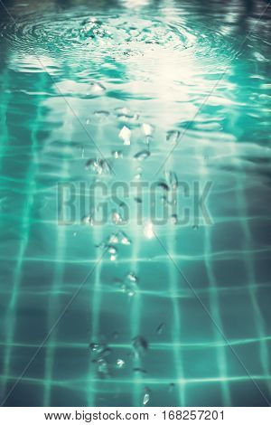 Swimming pool water surface with bubbles and ripples in transparent turquoise water with net pattern in vintage style