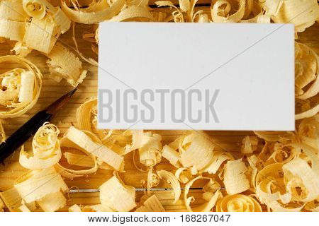 Blank business card on wooden table for carpenter tools with sawdust.Copy space. Top view.