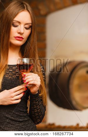 Woman Tasting Wine In Rural Cottage Interior