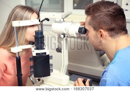 Ophthalmologist measuring intraocular pressure of young woman in clinic