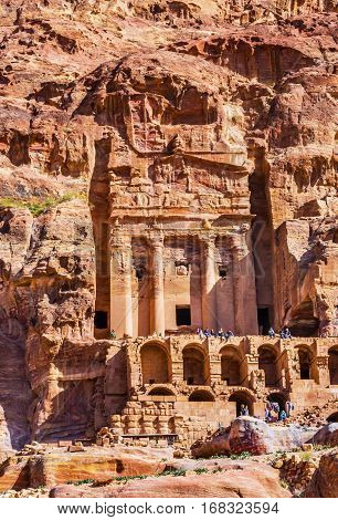 Rock Tomb Arch Tourists Petra Jordan. Built by the Nabataens in 200 BC to 400 AD. Yellow canyon walls become rose red in the afternoon.