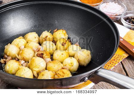 Fried potato dumplings with bacon in frying pan. Studio Photo