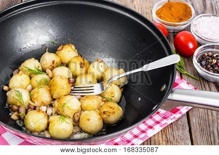 Fried potato dumplings with bacon in frying pan. Studio Photo