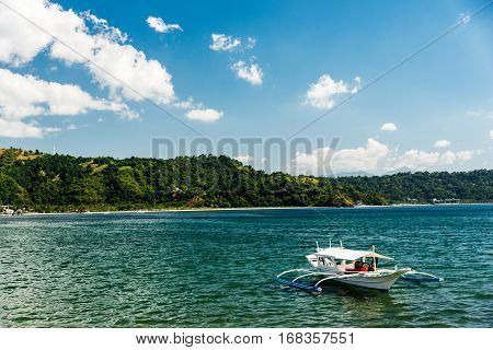 Small trimaran boat just outside the beach in Subic bay Philippines