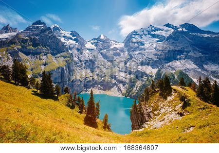 Panorama of the azure pond Oeschinensee. Popular tourist attraction. Picturesque and gorgeous scene. Location Swiss alps, Kandersteg, Bernese Oberland, Europe. Instagram toning effect. Beauty world.