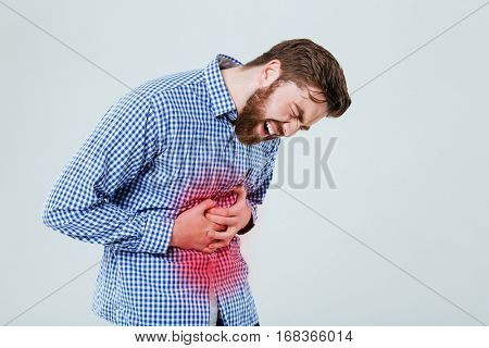 Man holding his hand on the stomach and feeling pain isolated on the white background