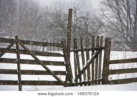 Snow is falling on a wooden fence at winter, mountain Kozomor, Serbia