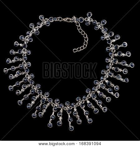 Golden necklace with sapphire and diamonds on black background
