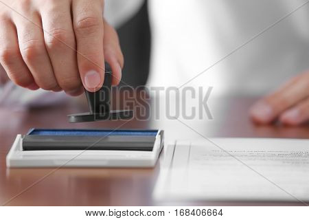 Notary public pressing stamp into ink pad
