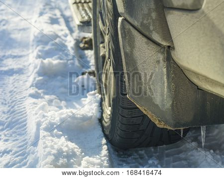 A rear of a vehicle with icicles on the splash guard outdoor cropped shot concept of the seasons change