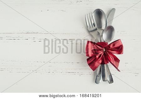 Valentine's Day tabble setting with cutlery on white shabby chic background. Valentine's Day place setting cutlery on white wooden background. Romantic love Valentines concept. Copy space. Top view.