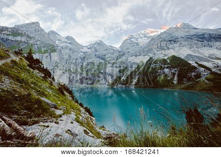 Glacier pond Oeschinensee. Popular tourist attraction. Picturesque and gorgeous scene. Location Swiss alps, Kandersteg, Bernese Oberland, Europe. Vintage effect. Instagram filtered. Beauty world.