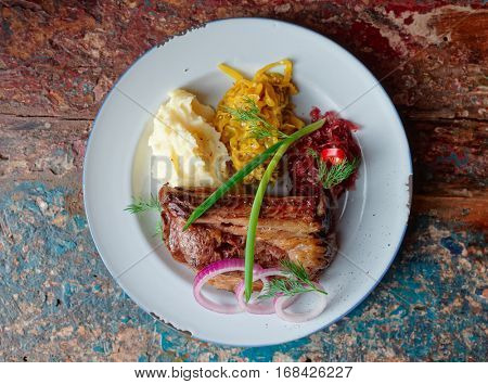 Grilled pork ribs with sauerkraut and mashed potatoes on restaurant table