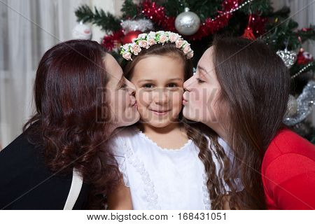 people, motherhood, family, christmas and adoption concept - happy mother and daughter hugging and kissing at home