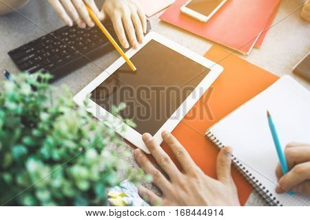Some hands in office shows to blank space on tablet pc. pointing with pencil and pen. black screen mock up